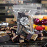 Wine barrel smoking wood chunks in a bag with the Midwest Barrel Co. logo and veggies in the background